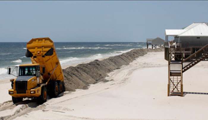 The image shows Crews build a sand berm to protect the island from the potential of oil washing onshore, on Dauphin Island, Alabama May 10, 2010. (REUTERS/Brian Snyder)