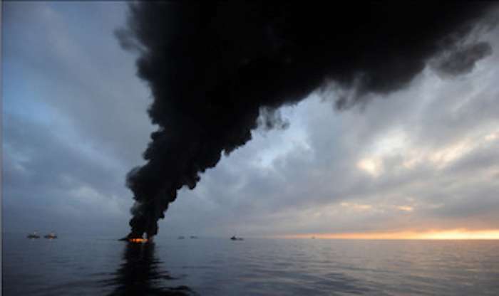 The image shows Dark clouds of smoke and fire emerge as oil burns during a controlled fire in the Gulf of Mexico May 7, 2010. (U.S. Navy photo by Mass Communication Specialist 2nd Class Justin Stumberg/Released)